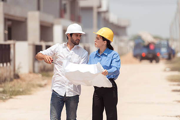 istock Architects and engineers work together to assess the residential home construction site's progress 2209499844