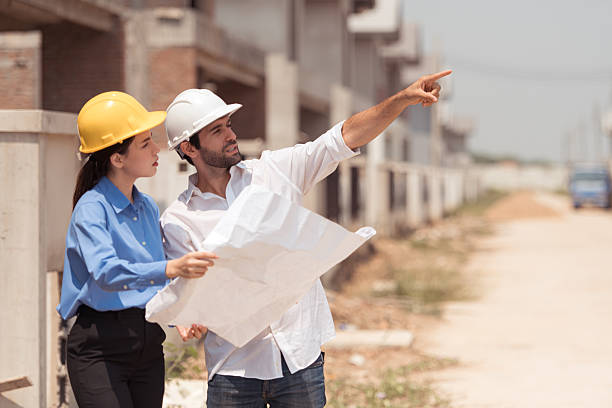 istock Architects and engineers work together to assess the residential home construction site's progress 2209499847