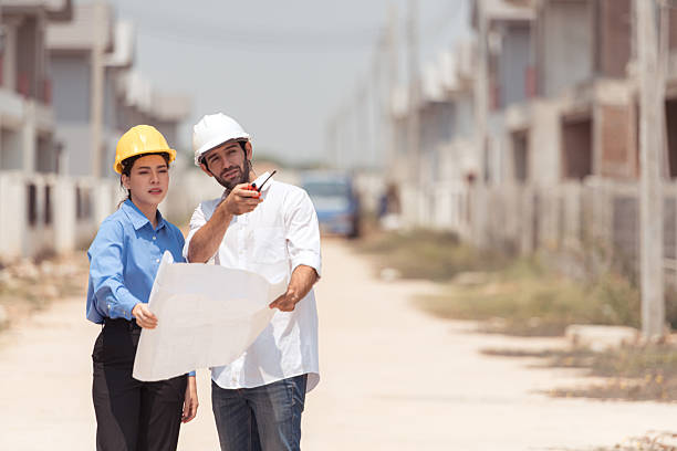 istock Architects and engineers work together to assess the residential home construction site's progress 2209499859