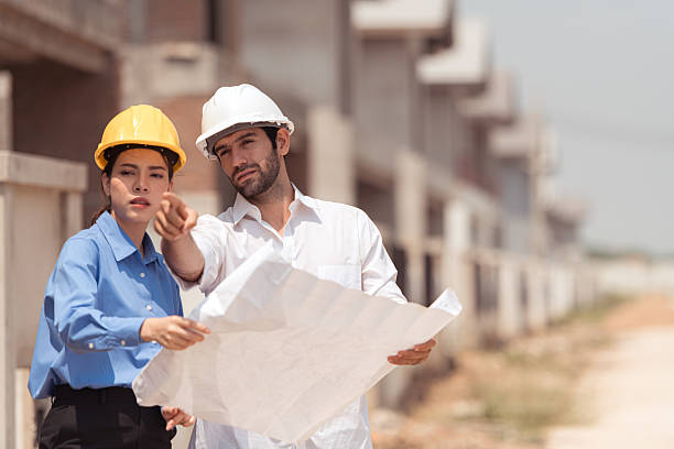 Architects and engineers work together to assess the residential home construction site's progress