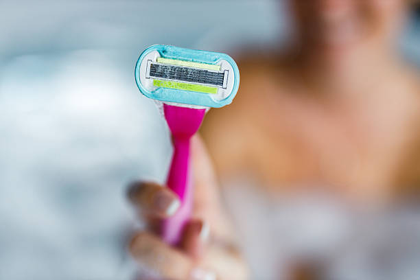 Close up of unrecognizable woman holding her razor in the bathroom.