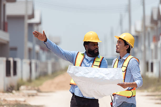 istock Architects and engineers work together to assess the residential home construction site's progress 2209501020