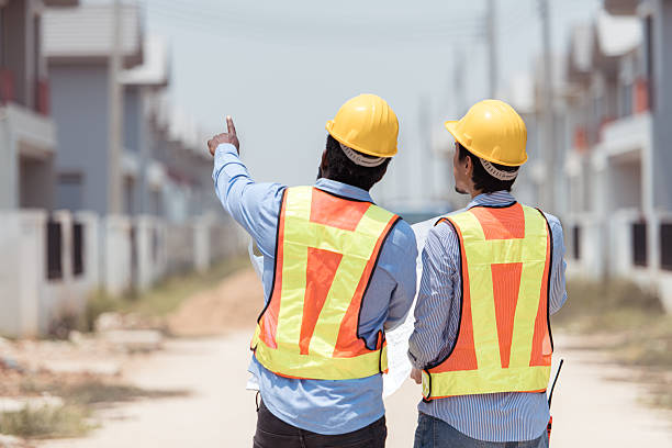 istock Architects and engineers work together to assess the residential home construction site's progress 2209501578