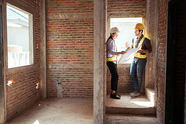 istock Architects and engineers work together to assess the residential home construction site's progress 2209502558
