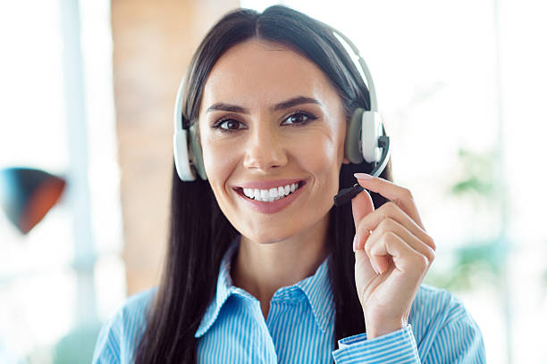 istock Professional Businesswoman Wearing a Headset Smiling Confidently in a Modern Office Setting with Natural Lighting 2209503909