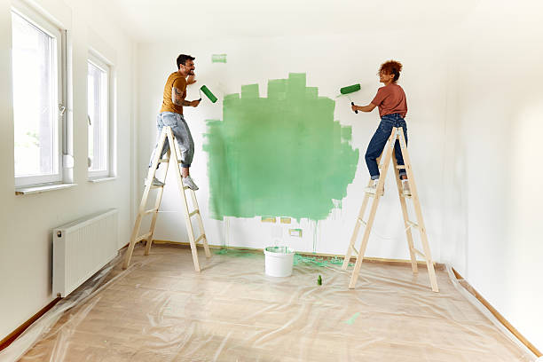 istock Happy couple talking while painting their new apartment. 2209504325