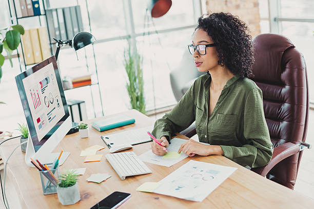 istock Young businesswoman working on analytics at a stylish workspace in bright natural light 2209504833