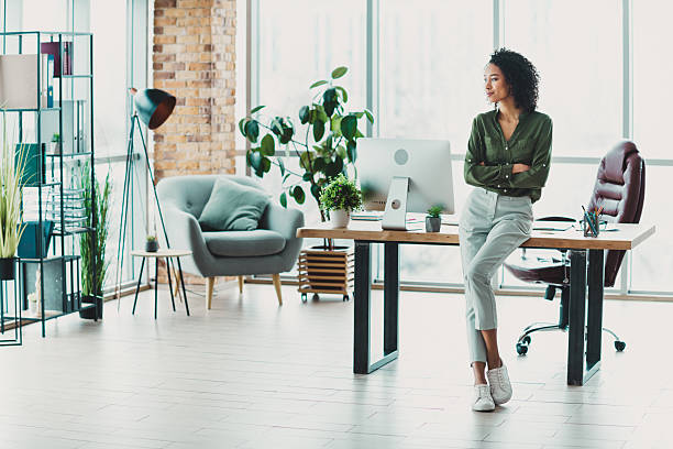 istock Confident young professional woman in a modern workspace with natural light and stylish decor 2209504948
