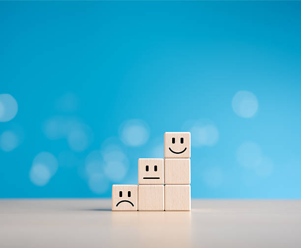 istock Wooden cubes stack with happy normal and sad face icons for experience survey services and product review concepts. Customer or Client shows good neutral or negative feedback and satisfaction ratings. 2209505987