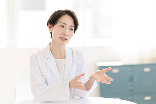 japanese woman in white coat - 診察 ストックフォトと画像