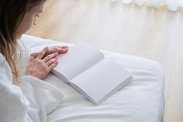 istock woman reading blank opened book lying on bed 2209507122