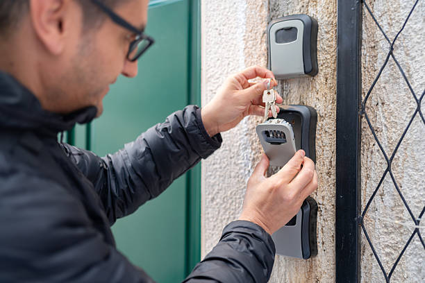 Key Lock Box For Rental Apartments Outdoor Male Tourist Opening Up A Code Box To Get The Door Key From Rented Apartments key package stock pictures, royalty-free photos & images