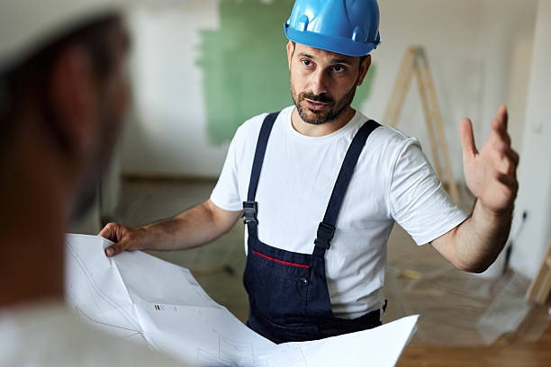 istock Manual worker talking to his colleague about housing project during home renovation process. 2209508743