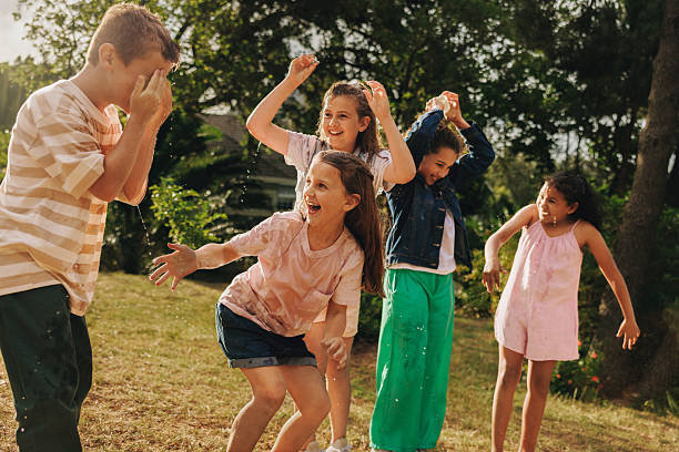 istock Children playing outdoors with water and laughter on a summer day 2209508966