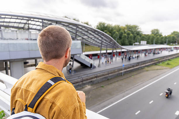 istock Man Observing Busy Train Station from Overpass 2209513073