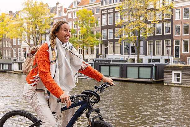 istock Woman Cycling by a Canal with Backpack in Autumn 2209513202