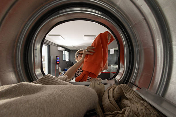 istock Mature woman in self-service public laundry 2209513390