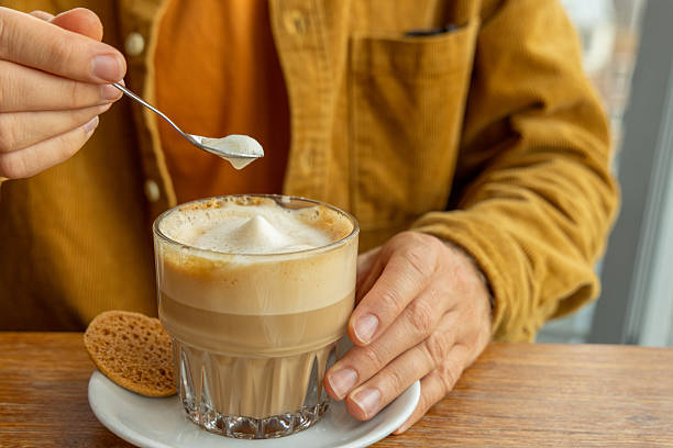 A man enjoys a chai latte in a cafe with Amsterdam city view