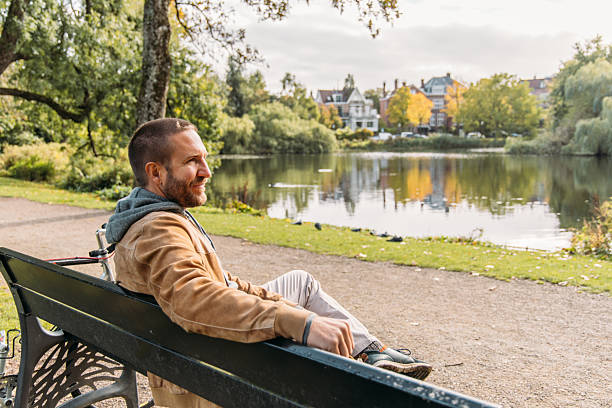 istock Man Relaxing by Idyllic Lakeside on a Sunny Day 2209513582