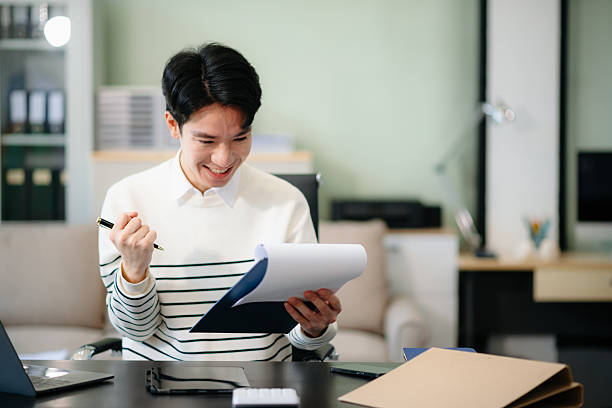 istock Confident  Asian businessman typing laptop computer and digital tablet at office 2209517470