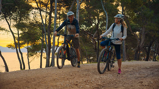 istock Active Cyclists Pause On Coastal Forest Trail During Golden Sunset Hour 2209522949