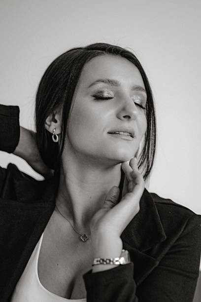 istock A woman is wearing a black jacket and a necklace 2209523495