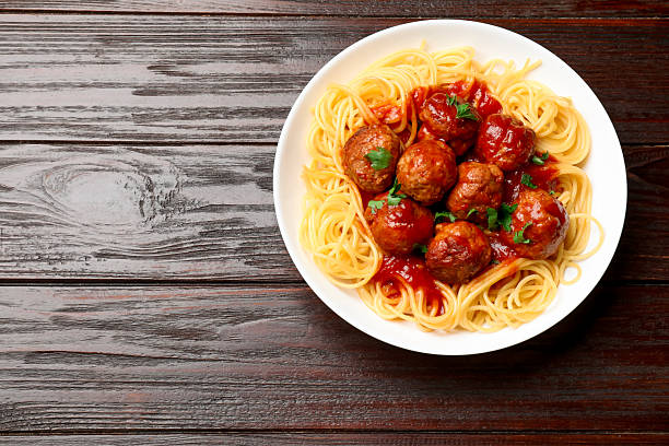 istock Delicious pasta with meatballs on wooden table, top view. Space for text 2209523904