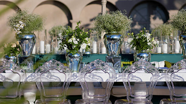 Beautiful floral arrangements used as table decorations at a wedding ceremony. The image captures the romantic and festive atmosphere of a wedding, featuring carefully arranged flowers that add elegance and charm to the celebration. Perfect for themes related to weddings, event planning, floral design, and special occasions.
