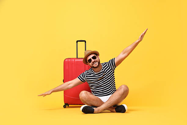 istock Happy man in sunglasses and suitcase on orange background 2209524883