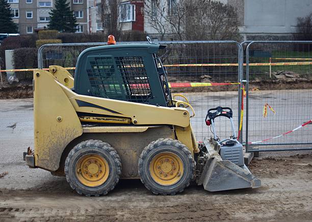Mini excavator standing near street reconstruction site ready to start digging.