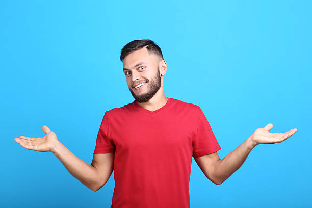 istock Young man in red t-shirt on blue background 2209527321