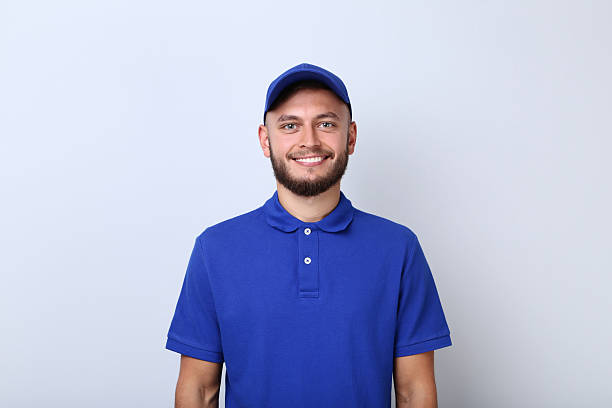 istock Delivery man in blue uniform on grey background 2209527499