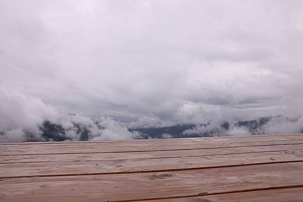 Wooden surface and beautiful mountains covered with fog