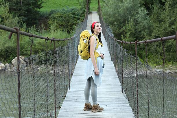 istock Young hiker on wooden bridge over river 2209527725