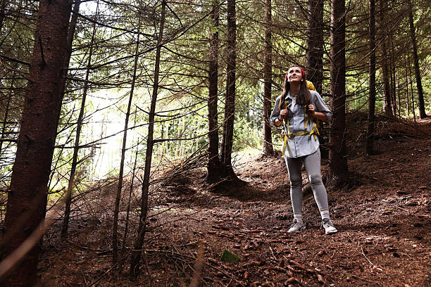 Young hiker with backpack enjoying time in forest