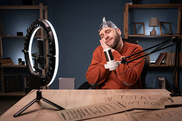 istock Crazy conspiracy theorist blogger streaming live at home using smartphone and ring light, making sleep gesture in adorable expression 2209530899