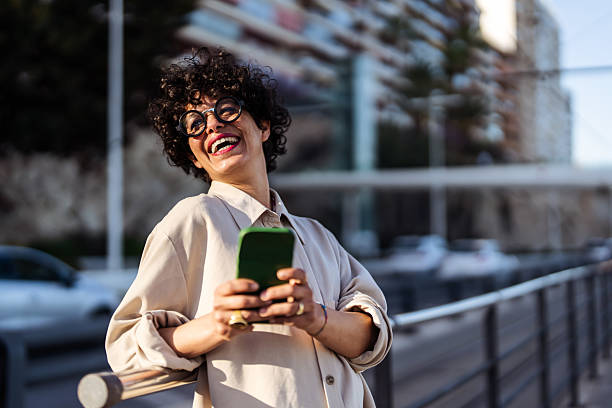 Smiling Woman Using Smartphone Outdoors in Urban Environment
