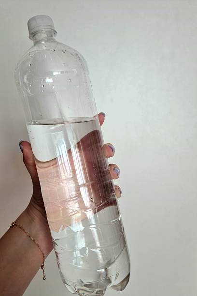 istock A clear plastic bottle of water is held in a person's hand 2209533758