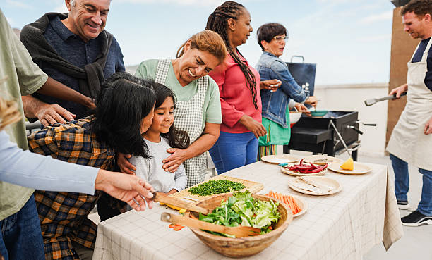 istock Multi generational people doing barbecue at home's rooftop - Multiracial friends having fun eating and cooking during weekend day - Summer and food concept - Main focus on kid face 2209539163