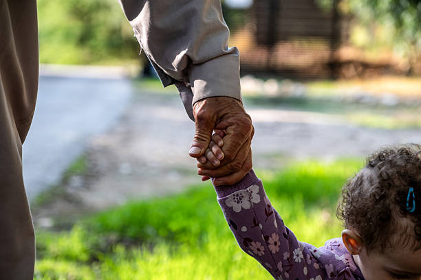 Woman and child standing in corridor holding hands. Outdoor family portrait for design and print. Kid aged three years (three-year-old boy)