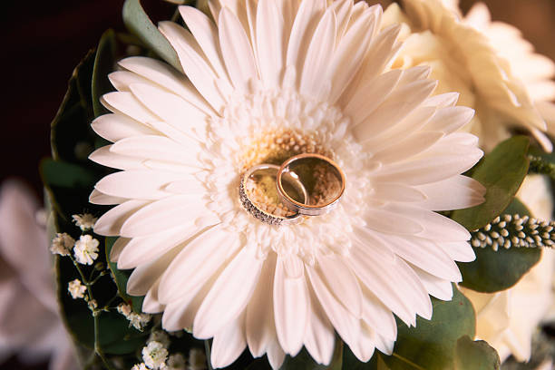 Photo of wedding rings on a white flower of a Biedermeier bouquet.