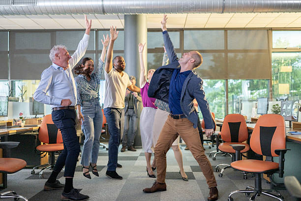 istock Cheerful Diverse Team Celebrating Success in Bright Modern Open Concept Office 2209543411