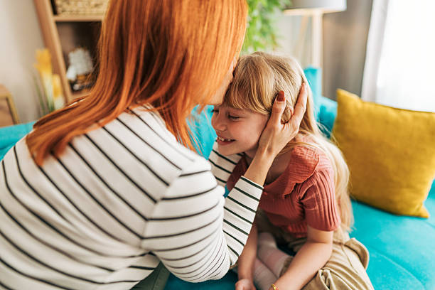 istock Mother embracing her smiling daughter at home 2209543691