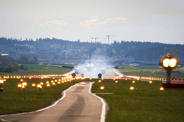 istock Commercial airplane seen from behind just before touching down and landing on the runway. Ground level point of view, super-telephoto shot, early morning sunlight, no people 2209545818