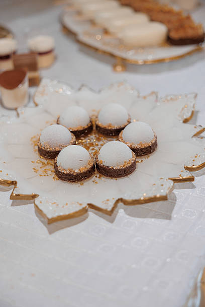 istock A white plate with a gold leaf design and a few white cookies on it 2209546648