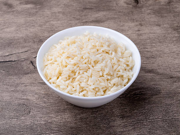 istock Cooked white rice in a bowl over wooden table 2209550492