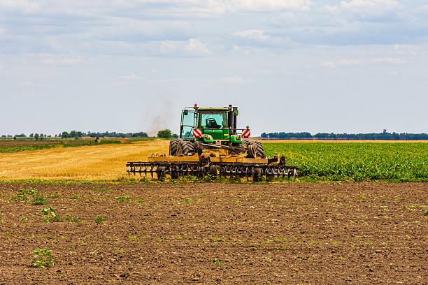 istock Tractor plowing field with the harrow. Agricultural concept 2209556092
