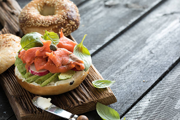 istock Bagel with salmon. White bagel with fish and herbs. 2209557673