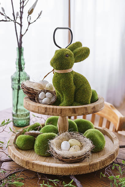istock Green moss Easter Bunny and decorative Easter eggs in nest on on two tiered wooden plate 2209558865