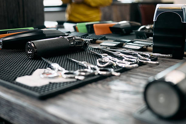 istock A variety of grooming tools including clippers, scissors, and combs are organized on a black mat at a barbershop. The vibrant atmosphere indicates an active work environment 2209559502